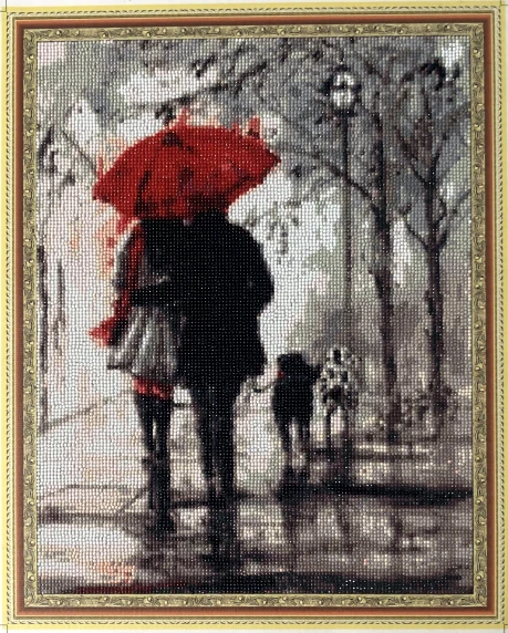 Handcrafted piece of a person holding an umbrella with a light post & a couple in the background